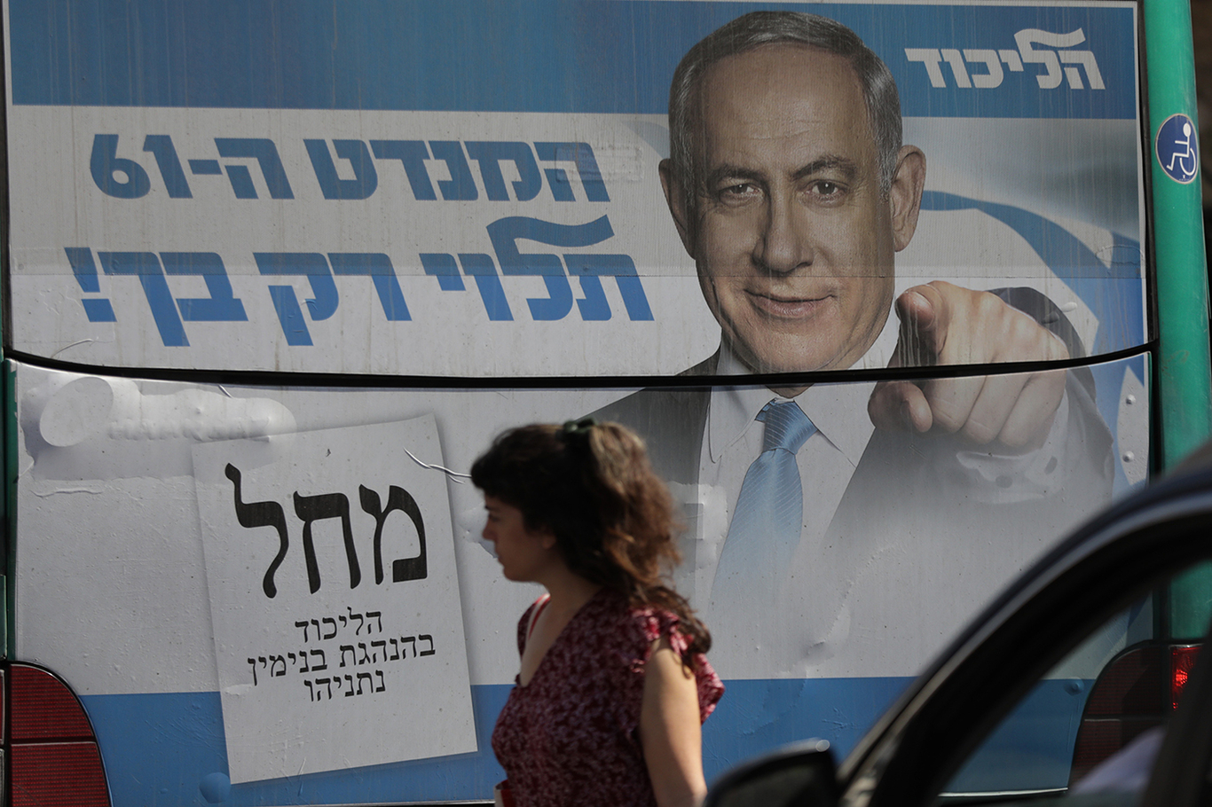 Женщина проходит мимо рекламного щита с изображением лидера партии «Ликуд» Биньямина Нетаньяху, Иерусалим, Израиль, 28 октября 2022 года. Фото: Abir Sultan / EPA